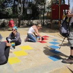 Painting a snakes and ladders game in the playground.