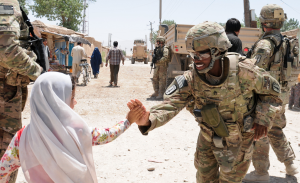 A female soldier high-fives a young girl in Afghanistan. Female soldiers play an essential role in warfare, especially in Iraq and Afghanistan. Photo by DVIDSHUB ? the Flickr Commons