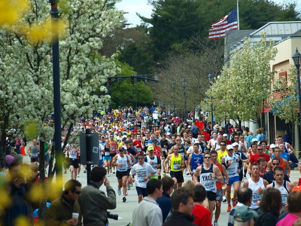 The 2010 Boston Marathon runners storm through Wellesley on their way to the Copley Square finish.  |  Photo courtesy of Wikimedia Common user Peter Farlow.