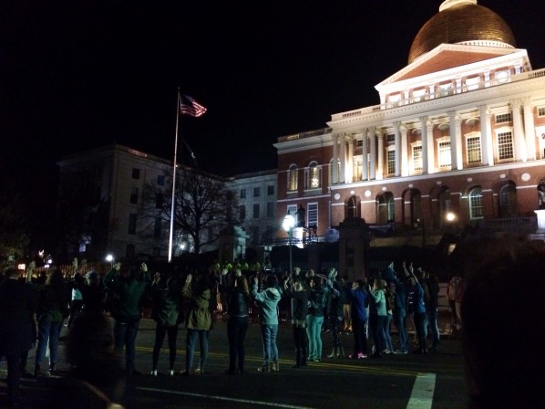 Protesters gathered in a circle in front of the State House. | Photo by Andrea van Grinsven
